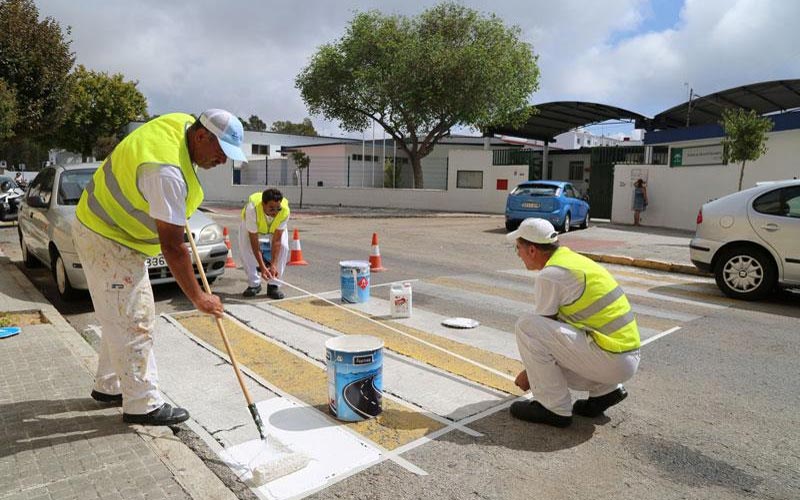 Parados del último Plan de Empleo Local repintan estos días los pasos de cebra cercanos a los centros escolares roteños