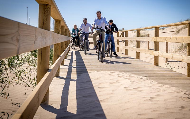 Paseo inaugural en bici de Moreno Bonilla por el controvertido Eurovelo entre Cádiz y La Isla, con un tramo “insostenible” impuesto entre dunas